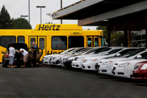 Pasajeros se suben a un bus de Hertz, una de las compañías que vería su negocio amenazado por Relay Rides.